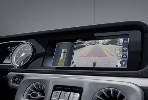 Mercedes-Benz G-Class — Reversing camera view with dynamic guide lines and a top-down parking graphic on the media display