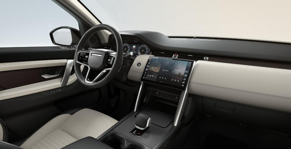 Land Rover Discovery Sport — Cabin with Light Oyster DuoLeather seats, Natural Shadow Oak veneer and a full-leather twin-nim steering wheel.