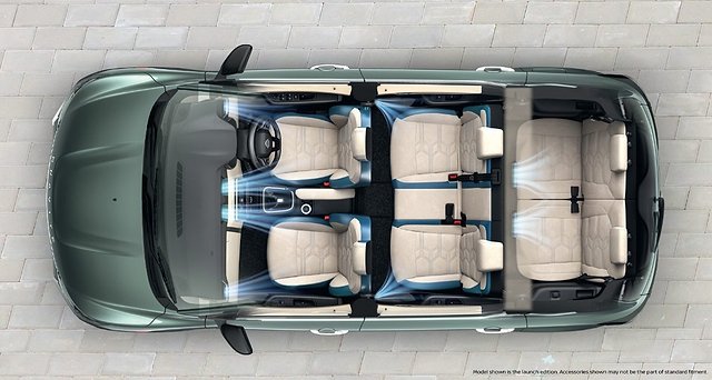 Overhead view of convertible SUV interior with six cream-colored seats and open roof.