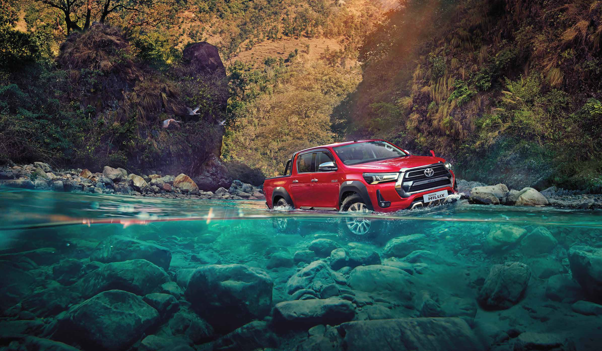 Toyota Hilux — Wading through a rocky river crossing.