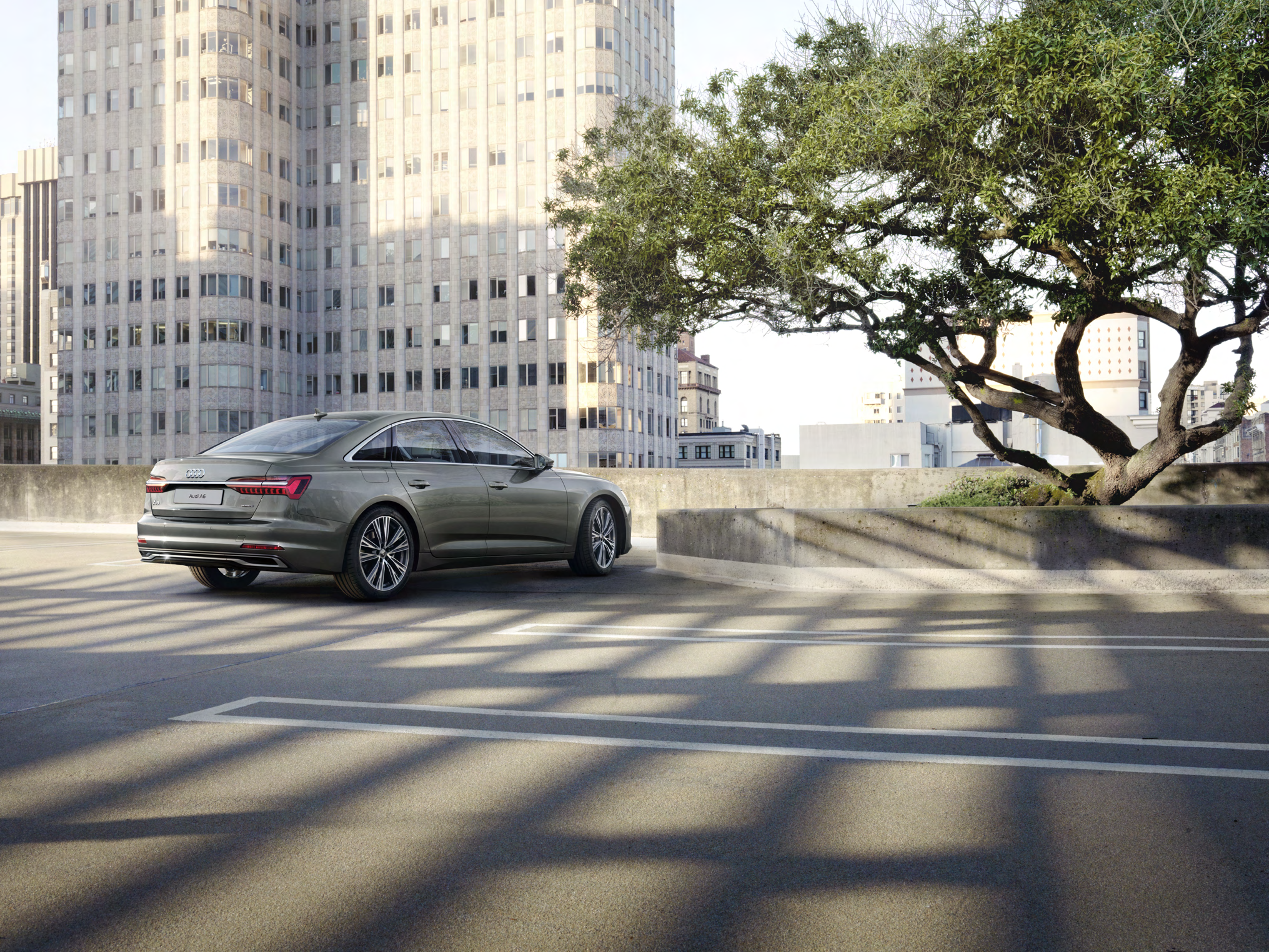 Audi A6 — Rear three-quarter profile with sculpted shoulder line and slim tail lamps