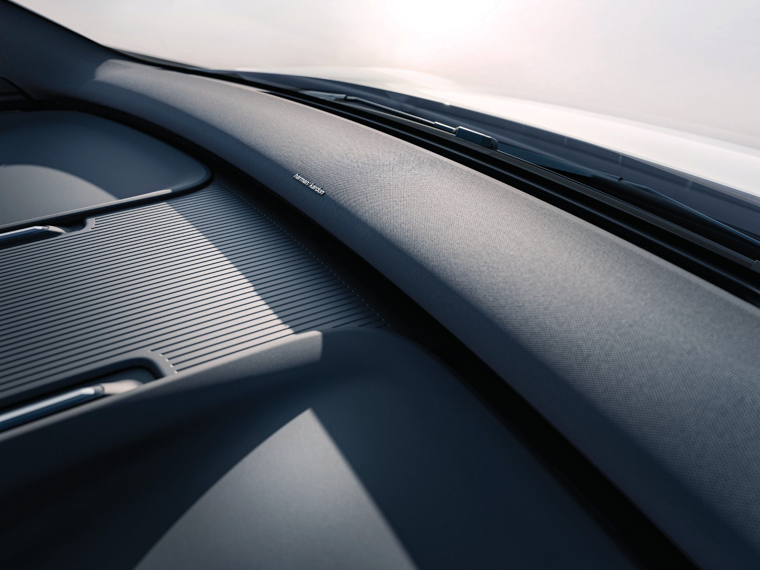 Volvo EX30 — Full-width soundbar-style speaker running along the base of the windscreen.