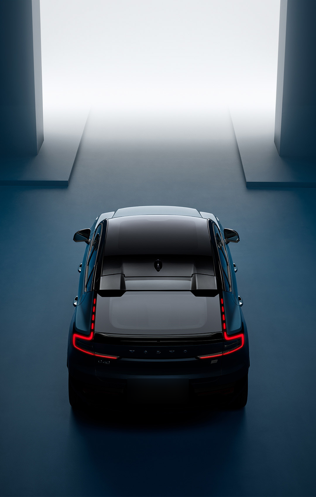 Volvo EC40 — Overhead view of the coupe-SUV rear showing the full-width connected LED tail-light signature and the slim roofline.