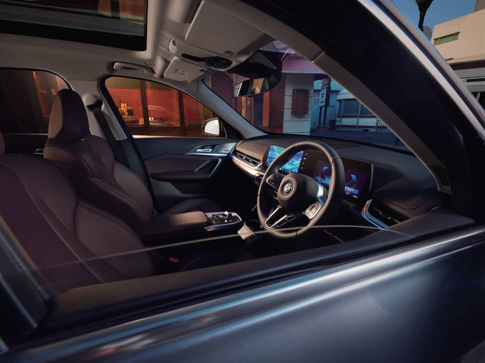 BMW iX1 LWB — Harman Kardon speaker with metal grille set into the ambient-lit door trim