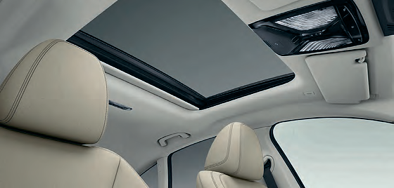 BMW i4, Panoramic glass sunroof with electric sunshade brightens the cabin beneath the light beige headliner.