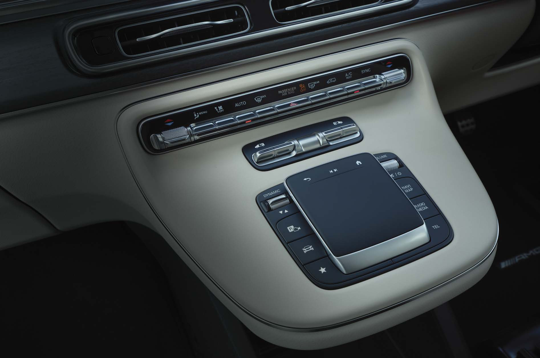 Mercedes-Benz V-Class — Centre-console touchpad controller with haptic feedback alongside the physical climate-control panel for the private suite.