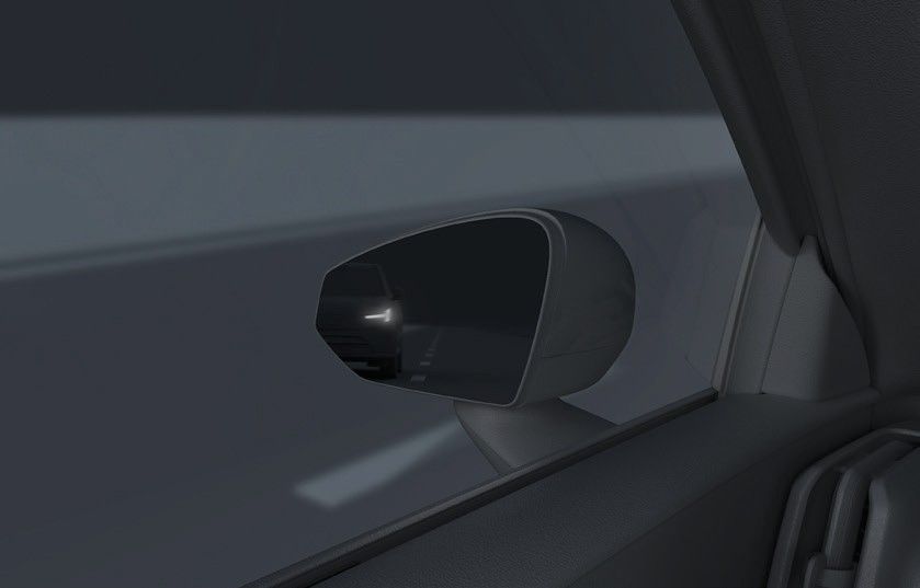 Volvo EX30 — Door-mirror blind-spot indicator illuminating as a vehicle approaches from behind.