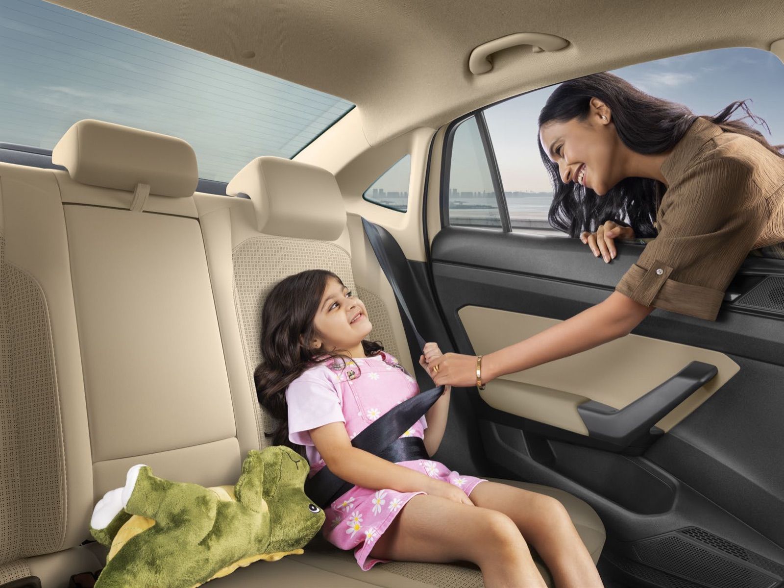 Rear seat of the 2026 Škoda Slavia in beige upholstery with a child being secured by a three-point seatbelt