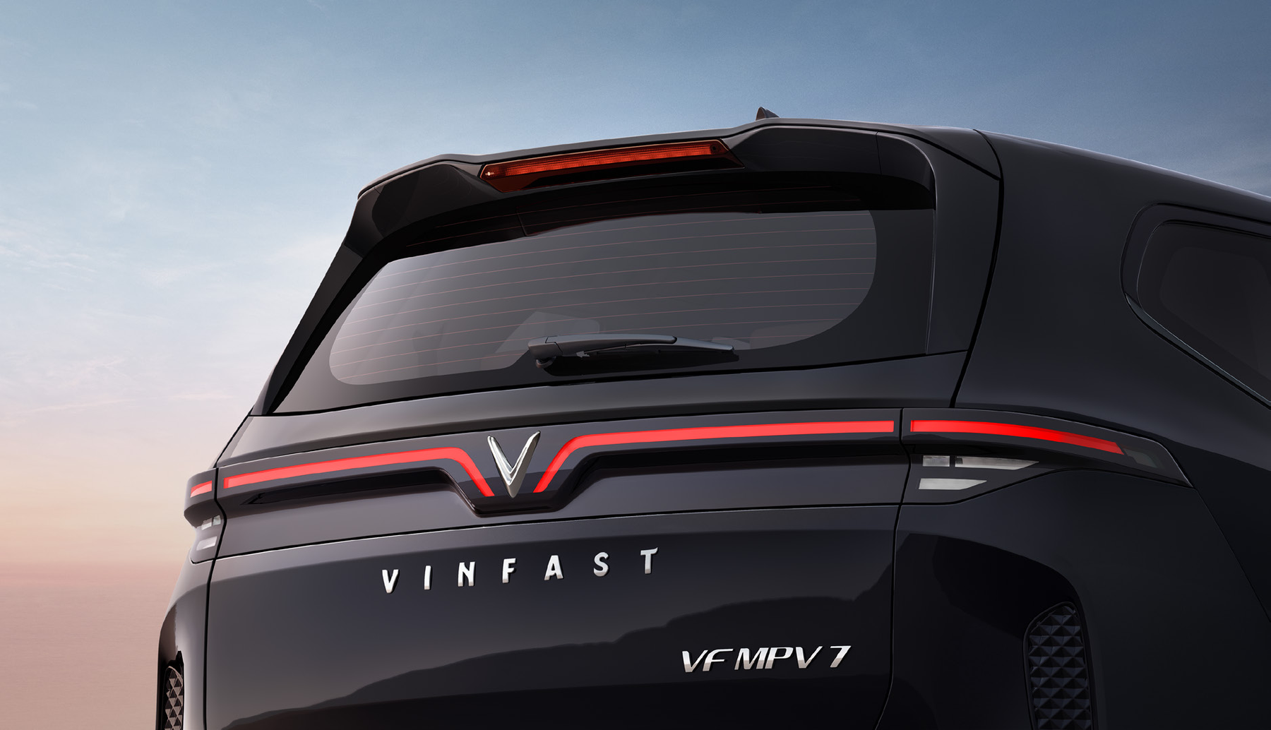 VinFast VF MPV 7 — Full-width connected LED tail lamp with roof spoiler and high-mount stop lamp